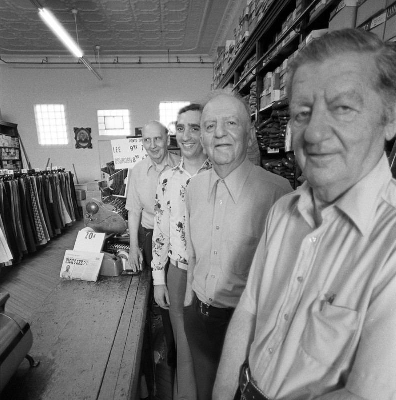 Four generations of clothiers man the counter at a small department store, western Upper Peninsula; 1976.Guide to Michigan; 1976. West UP.