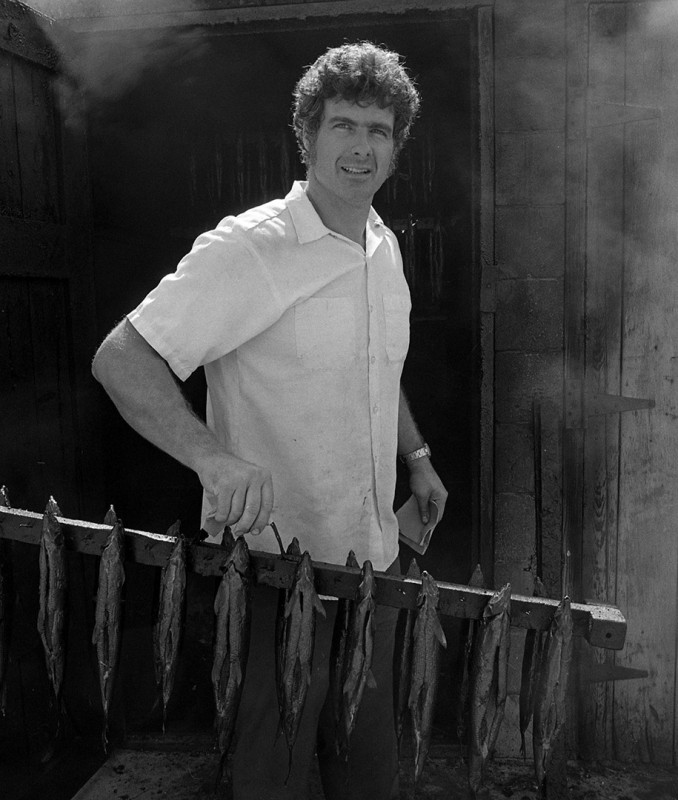 Bill Carlson, owner of Carlson Fisheries, clears out the smokehouse, Fishtown, Leeland; 1976.Guide to Michigan; .