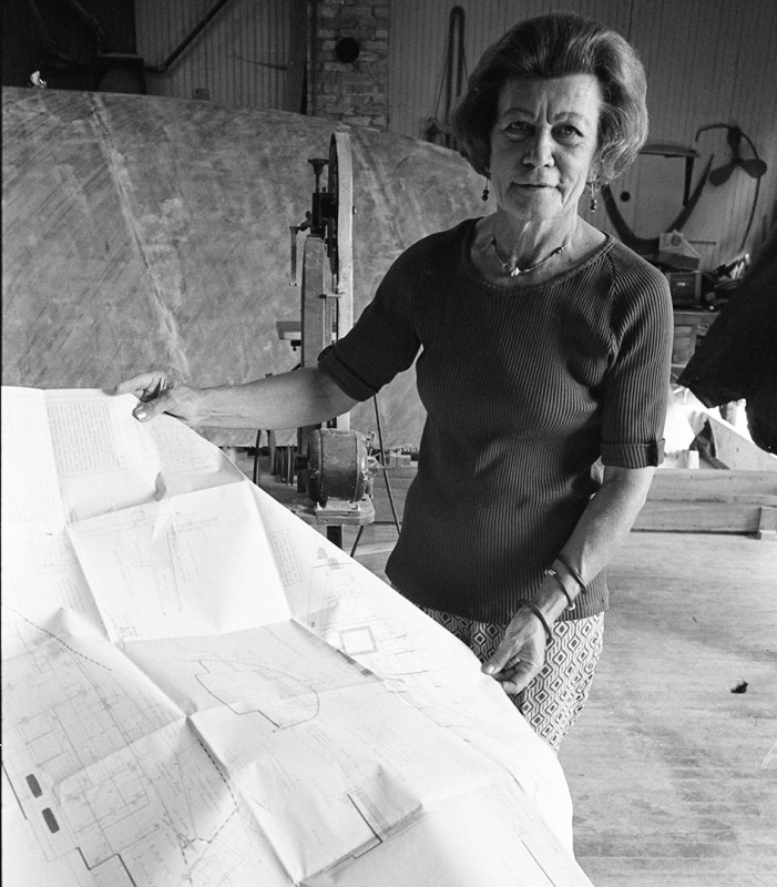 Eleanor Powell, owner of the Irish Boat Shop shows plans for a new ship, Harbor Springs; 1976.Guide to Michigan,.